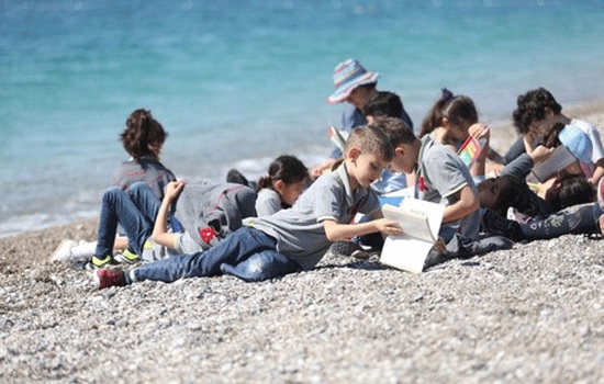 Тысячи студентов читают книги на южно-турецком пляже в рамках местного проекта